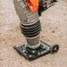 A jumping jack tamping rammer with a 7HP 209CC engine, predominantly black and orange in color, designed for soil compaction. Wheel view outdoors.