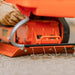 An orange and black SuperHandy wood chipper compact machine with a gas engine, designed for yard work. water drain view.