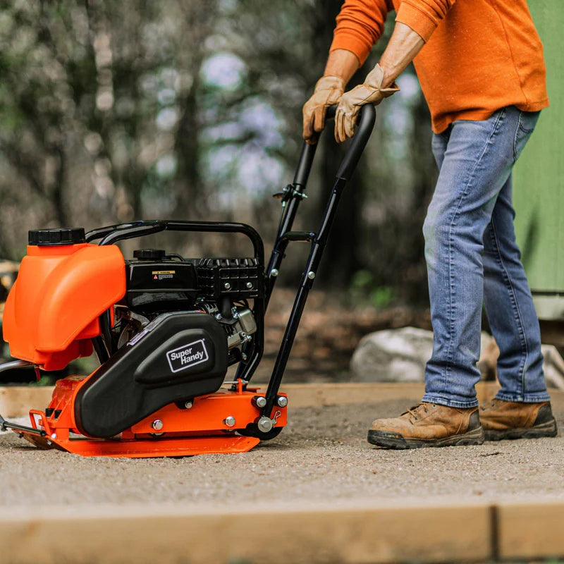 An orange and black SuperHandy wood chipper compact machine with a gas engine, designed for yard work. In use