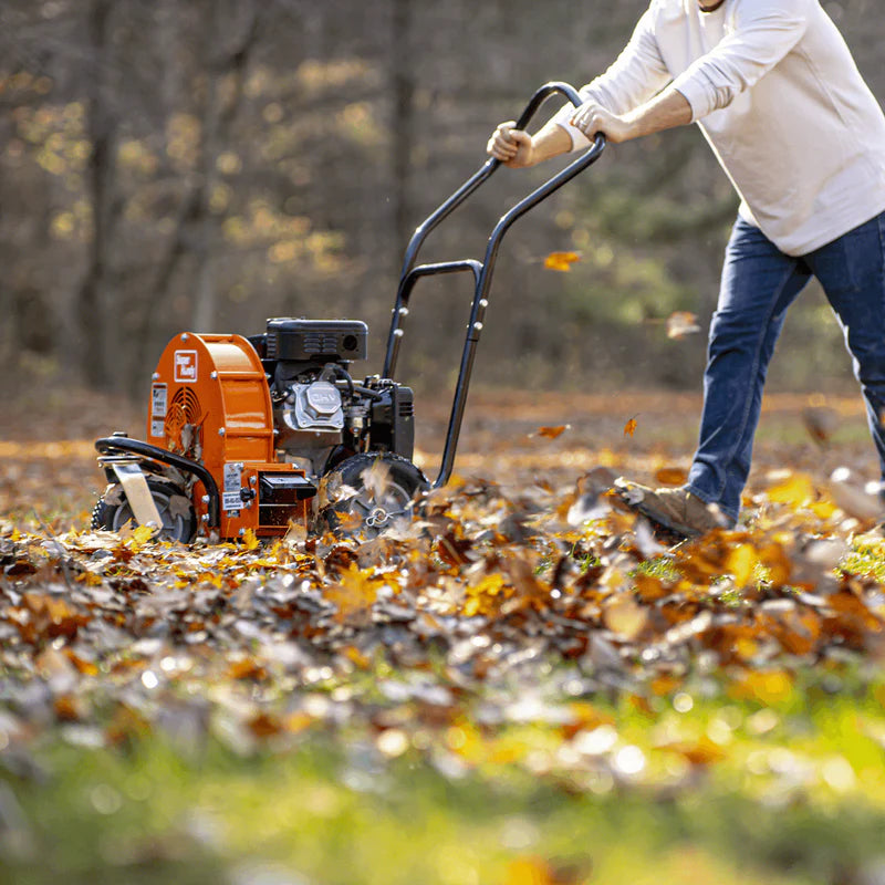 An orange and black SuperHandy walk-behind gas leaf blower with rugged all-terrain wheels and a 209CC gas engine. Side view outdoors in use.