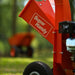 Orange superhandy mini wood chipper shredder mulcher with 'Super Handy' branding on the side of mouth chute in a blurred outdoor setting.
