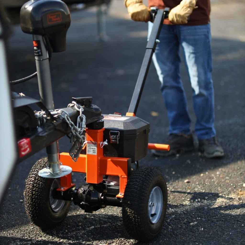 Person using a small orange superhandy 2800 lbs power dolly on a road