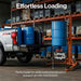 White truck with blue barrels being loaded using a superhandy drum lift 550 lb in a warehouse setting.