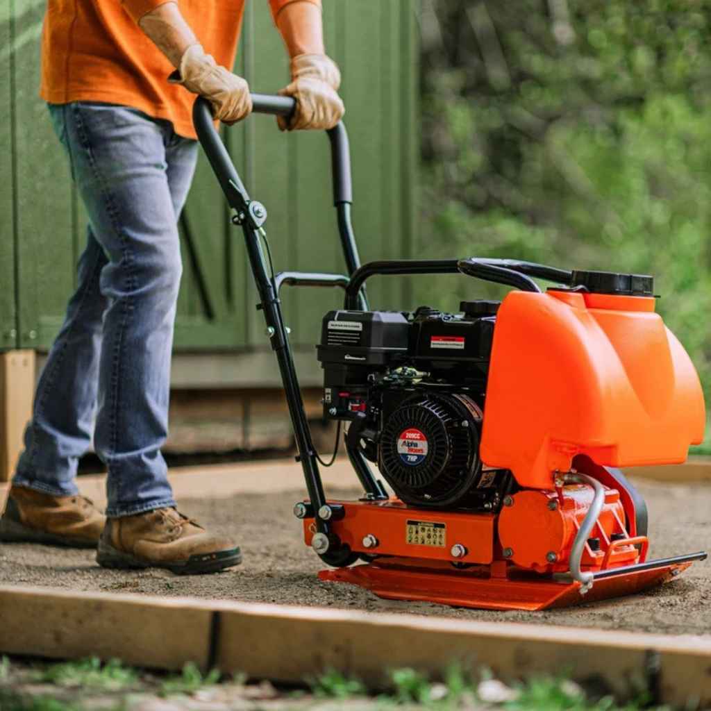 Person operating a superhandy plate compactor 7 hp with water tank
outdoors