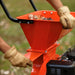 an orange and black superhandy 7hp woodchipper pro with leaves being shredded.