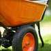 Orange super handy 24v electric wheelbarrow with 'Super Handy' branding on a grassy background