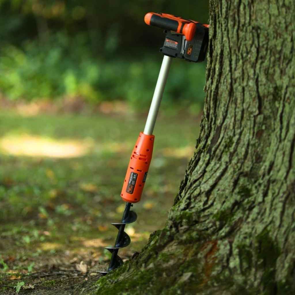 superhandy electric earth auger 20v attached to a tree trunk in a natural setting