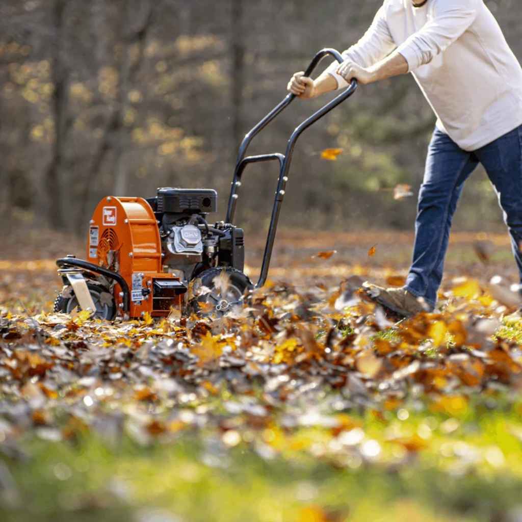 Person using a superhandy walk behind leaf blower to clear leaves in an outdoor setting