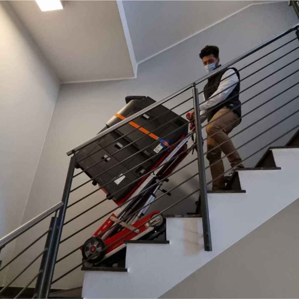 Person using a zonzini stair crawler buddy lift on a set of stairs in an indoor setting
